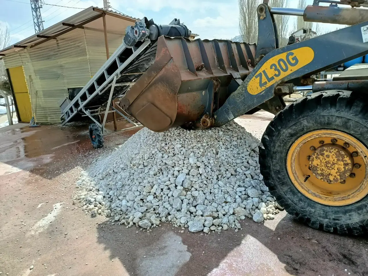 Loader moving crushed white barite ore at KHN Minerals