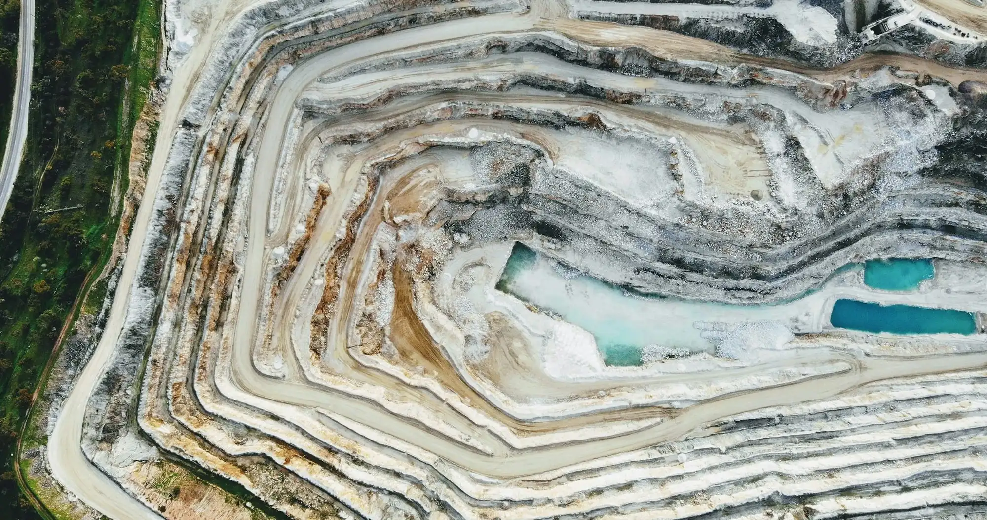 Aerial view of a terraced open-pit mine with white rock